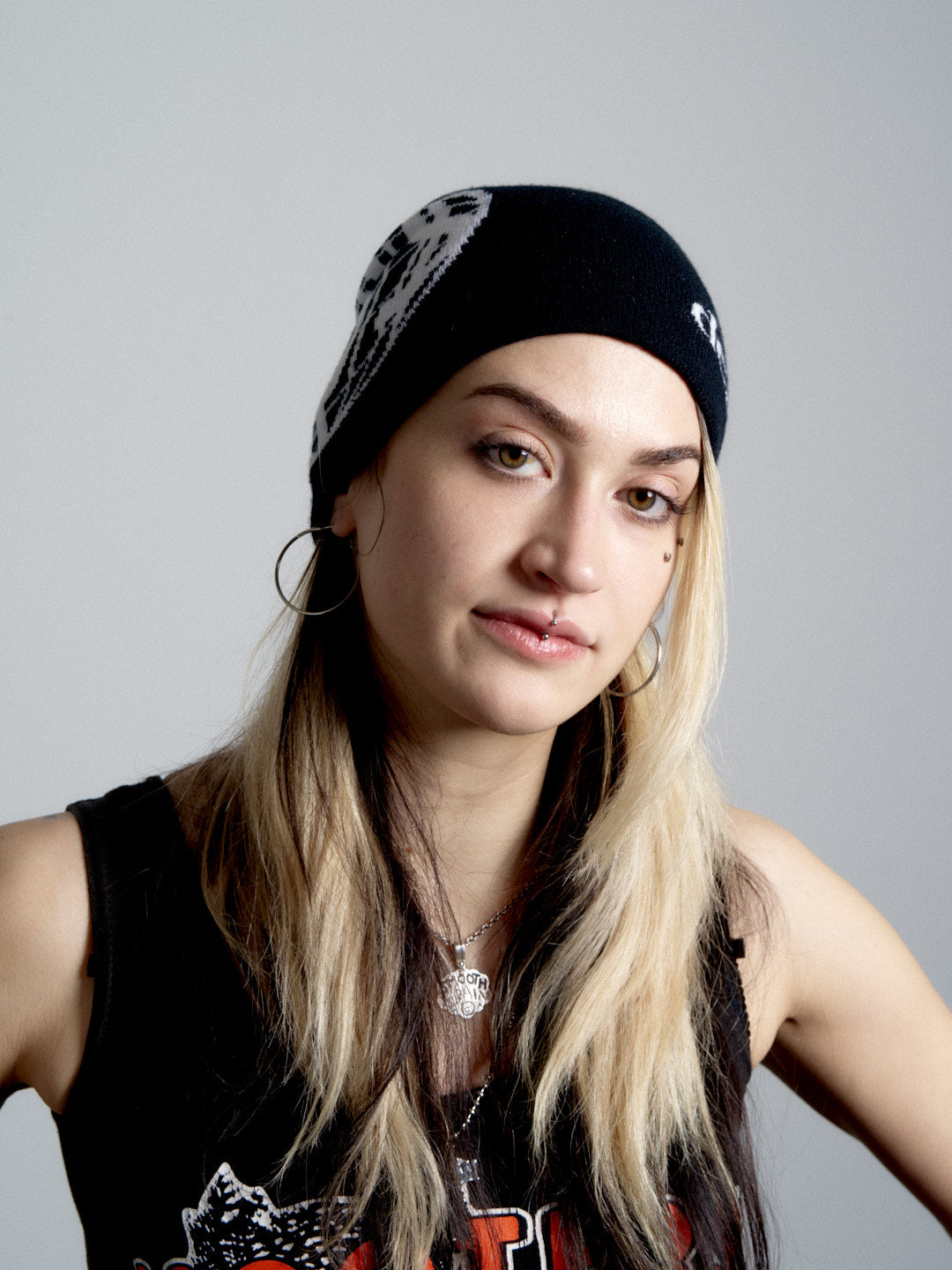 Person wearing a deadHYPE Graphic Beanie (Black), sleeveless top, and necklace on a gray background