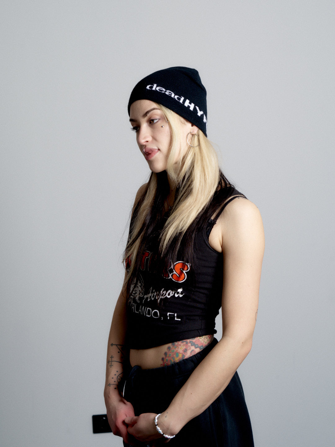 Person wearing a black crop top with visible branding and a deadHYPE Graphic Beanie (Black), standing against a plain background.
