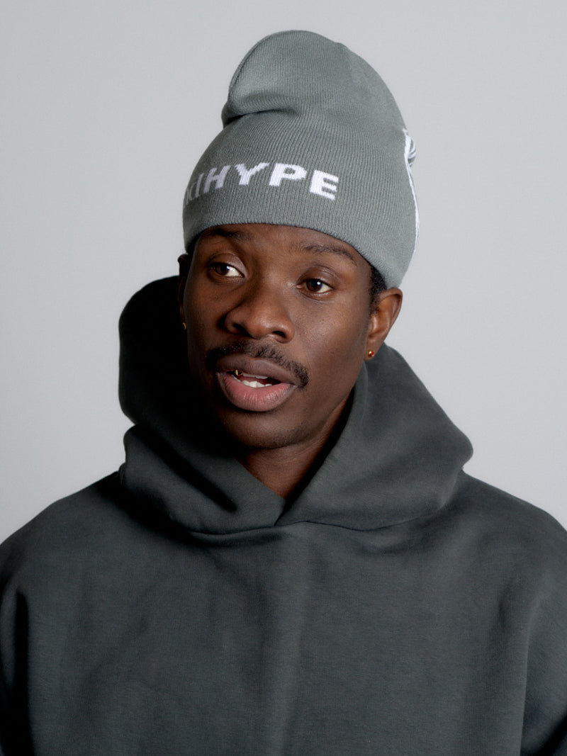 Person wearing a gray 'HYPE' beanie and dark hoodie against a plain background