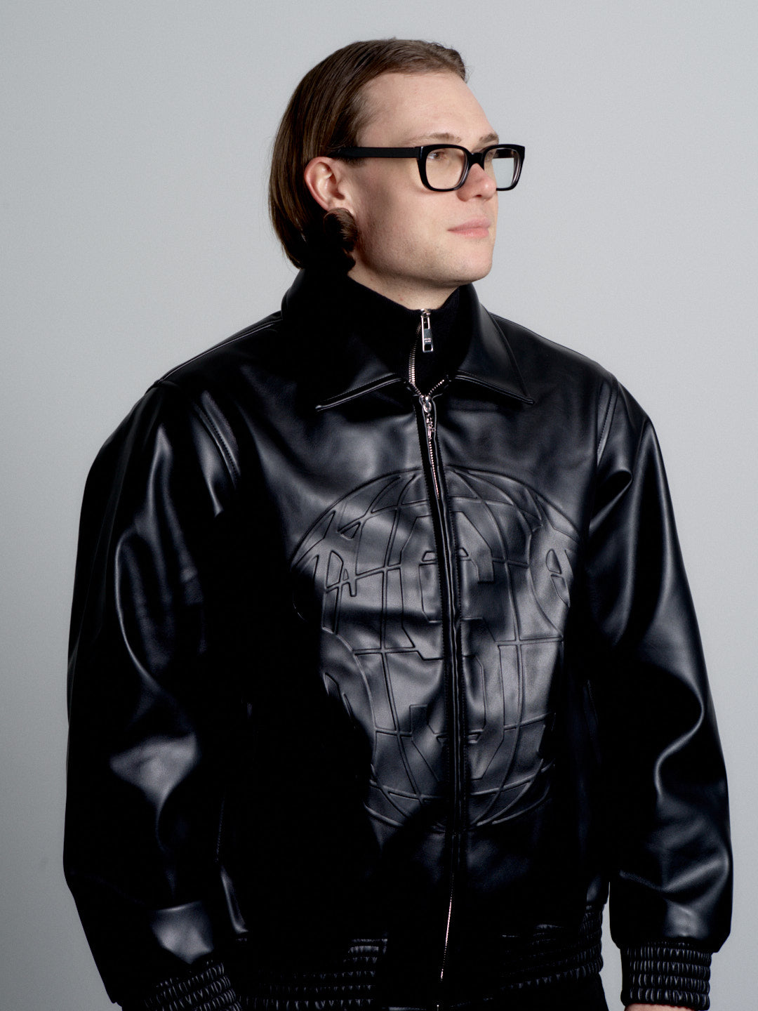 Person wearing a deadHYPE Vegan Leather Jacket (Black)  with a brand logo on a gray background